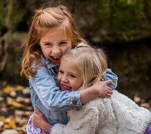 Tips to Raising Happy Kids - sisters hugging